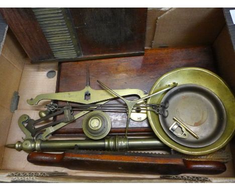 A set of brass bankers scales on a wooden stand and a brass and wooden apothecary pill rolling machine