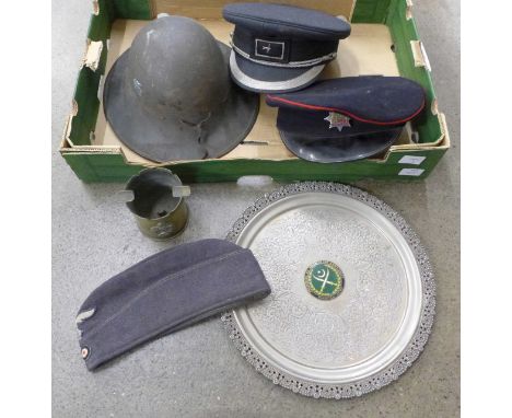 A brass trench art ashtray, tray with Pakistan Army badge, two peaked caps, German Luftwaffe side cap and a helmet 