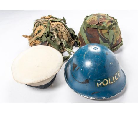 A British Army kevlar helmet, a 1970's turtle helmet with full camouflage garnish and hessian cover; a turtle helmet in polic