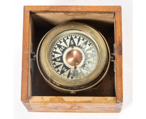 A Ship's brass compass by Norie &amp; Wilson, London. Mounted on a gimball in a wooden box with sliding lid. Approx diameter 