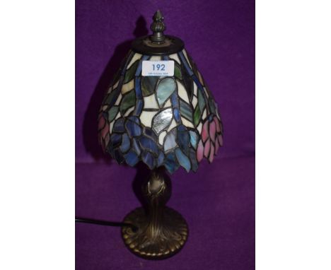 A modern Tiffany style lamp having brass stem and purple,pink and blue green hues to shade.