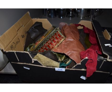 A box of leather and suede off cuts and a tin containing tools such as crotchet hooks, tape measures and more.