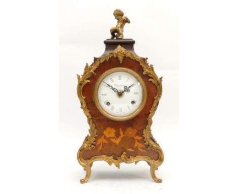 A 20th century Italian brass and walnut mantel clock with a convex dial, topped with the figure of a cherub, having an eight 