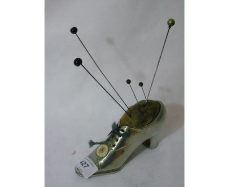 Antique white metal pin cushion in the form of a shoe with enamel Isle of Man badge. Approx 6"