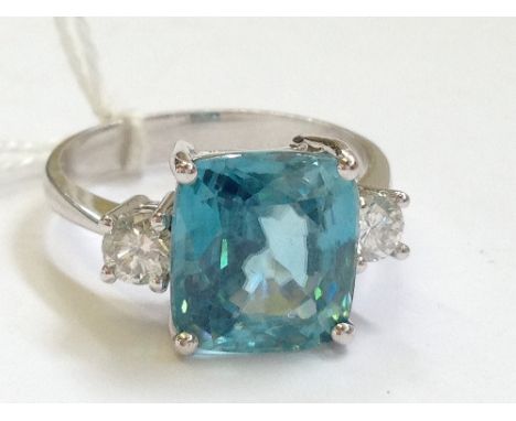 An 18 carat white gold natural blue zircon (8 carat) and diamond shoulder set ring.
