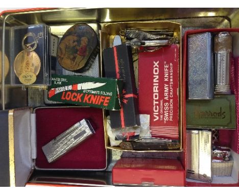 A tin of collectables including a 19th century snuff box, cigarette lighters, pen knives and other items.