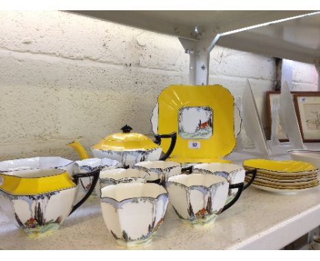 The residue of a Shelley Queen Anne shape bone china tea service decorated with cottages with red rooves on yellow ground.  
