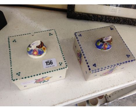 Two Poole Pottery square shaped honey boxes with bee finial lids, decorated in the CL and BF patterns (examine).