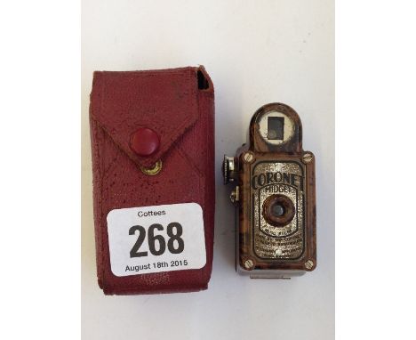An early 20th century brown Bakelite cased coronet Midget camera in original purple leather case.
