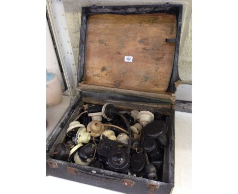 A box containing a large quantity of early 20th century Bakelite ceiling light bulb holders and light switches.
