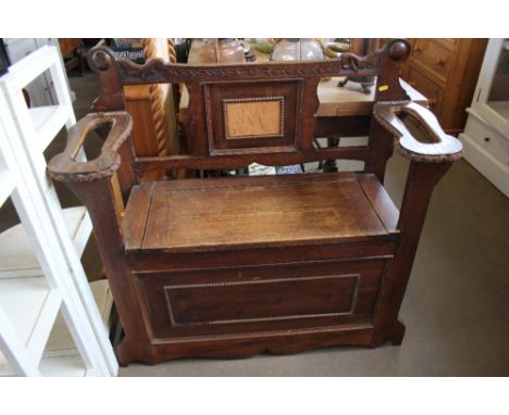 An oak monks bench with stick stands to side