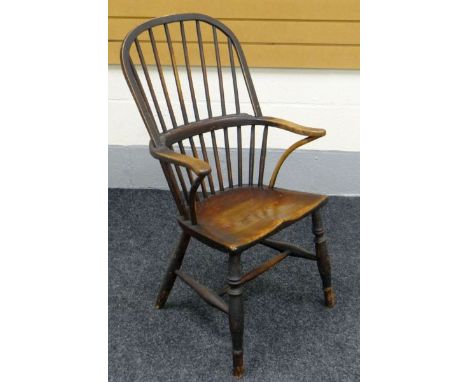 AN ELM WINDSOR ELBOW CHAIR on turned supports and having a two stage stick back and curved arms