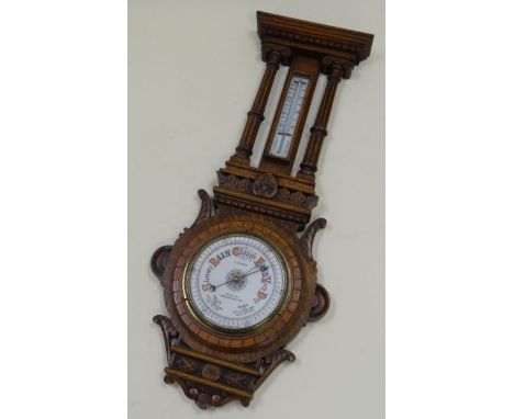 AN OAK ENCASED BAROMETER & THERMOMETER SET the case heavily carved with fluted pillars and having white enamel dials, inscrib