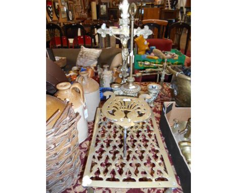 A brass crucifix, two trivets and a lamp
