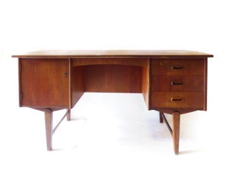 A 1970's teak desk, the bowed rectangular surface above an arrangement of three drawers, two doors and a shelf, w. 133 cm   C