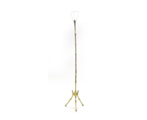 A 1950's French faux bamboo brass standard lamp on a tripod base   CONDITION REPORT:  Shaft slightly bent, lead cut, working 