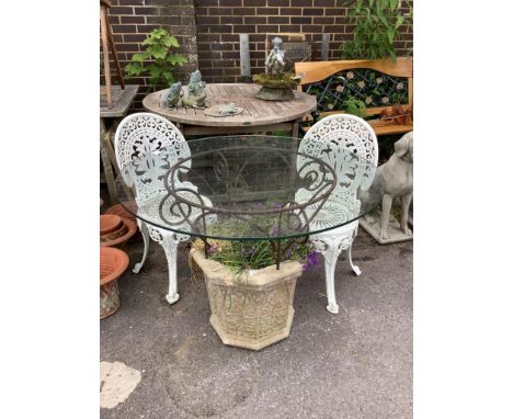 A reconstituted stone and wrought iron glass top garden planter / table, diameter 100cm, height 77cm, together with a pair of