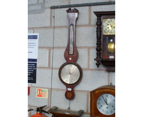 A George III mahogany wheel barometer , the thermometer flanked by two oval inlaid conch shells.