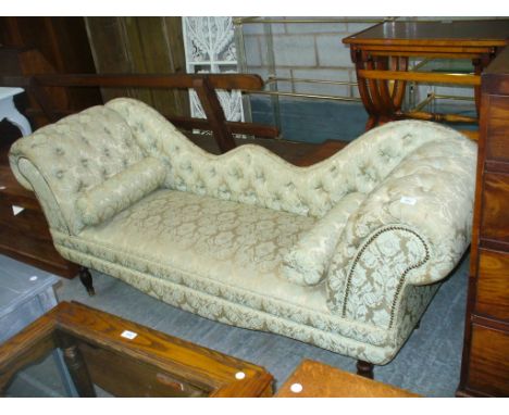A Victorian style damask chaise lounge with a shaped button back and double scroll ends.