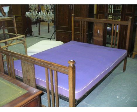 An Early 20th century oak double bed frame , the central panel with a moulded lozenge.