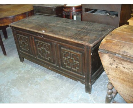 A 17th Century and later oak coffer with a geometrically moulded four panel front, stile feet.