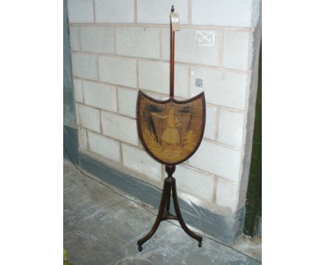 A 19th Century mahogany shield shaped pole screen , the needlework panel depicting a figure amongst foliage , raised on three