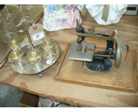 A Victorian silver plated egg cruet with 6 removable egg cups the stand with a scalloped border raised on egg and claw feet a