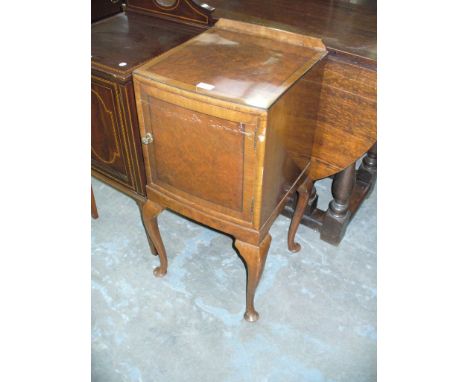 A Heals of London early 20th century burr walnut bow front pot cupboard raised on cabriole legs.