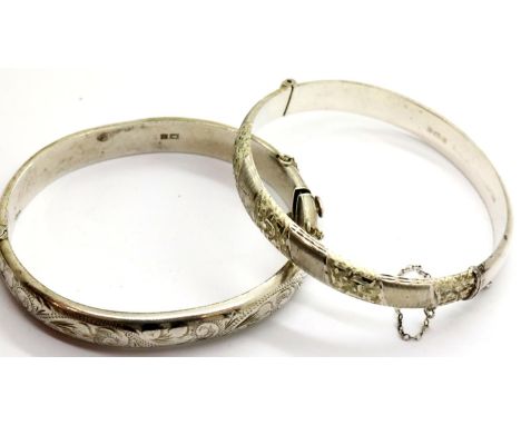 Two silver bangles, one engraved with foliate design, the other bright cut. P&amp;P Group 1 (£14+VAT for the first lot and £1