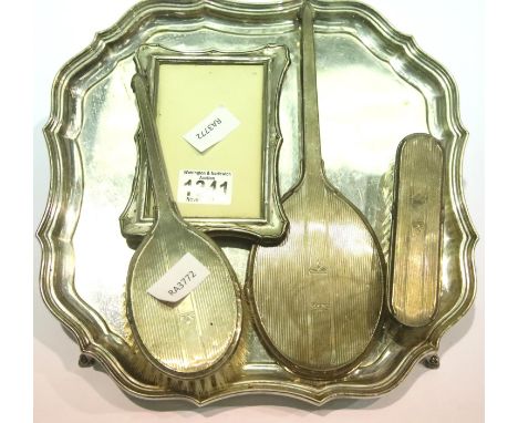 Shaped silver plated tray containing hallmarked silver brush set and a Chester hallmarked silver photograph frame. P&amp;P Gr