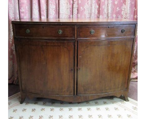 Maple &amp; Co. Regency style mahogany bow front sideboard outlined with ebonised stringing, two cockbeaded drawers and two d