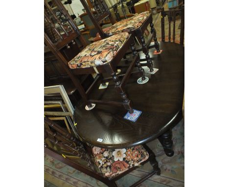 A DARK ERCOL OAK EXTENDING DINING TABLE WITH FOUR MATCHED ERCOL CHAIRS