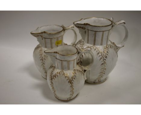 A GRADUATED SET OF THREE ROYAL WORCESTER STYLE JUGS WITH BACCHANALIAN MASK DETAIL  (3)