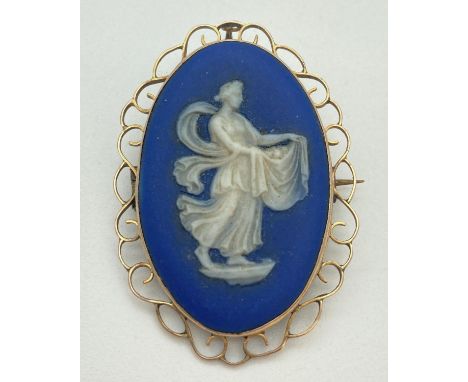 An antique 9ct gold mounted Wedgwood blue &amp; white jasper ware brooch. Large oval ceramic plaque of a maiden, stamped to r