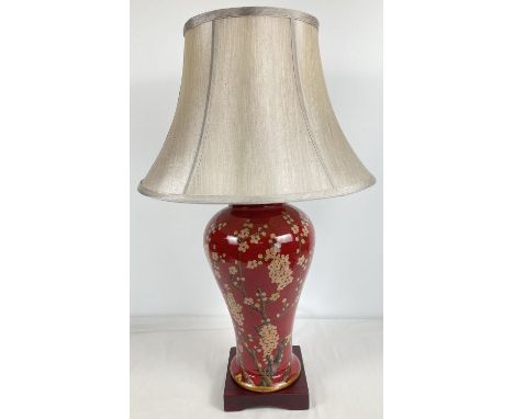 A modern ceramic Mandarin Arts Limited table lamp in deep red glaze with painted peach blossom design. Raised on a square sha