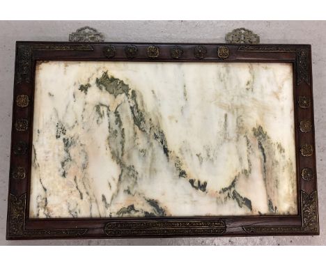 A large Oriental wall hanging stone panel in dark wood frame set with decorative brass plaques. Approx. 44cm x 68.5cm, weighs