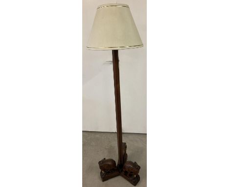 A vintage ethnographic hardwood standard lamp with 3 carved wooden elephant feet. Complete with cream lightshade. Height excl