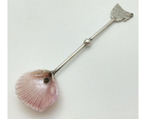 A Stewart sterling silver handled cruet spoon with bowl made from a shell. Spoon finial is engraved in the form of the outlin