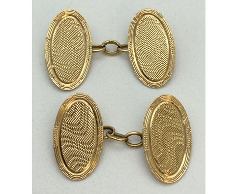 A pair of vintage 18ct gold chain link cufflinks with engine turned decoration. Oval shaped panels, fully hallmarked to rever
