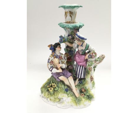 A Meissen figural candlestick of a gent and a lady in a garden setting, approx height 23.5cm.