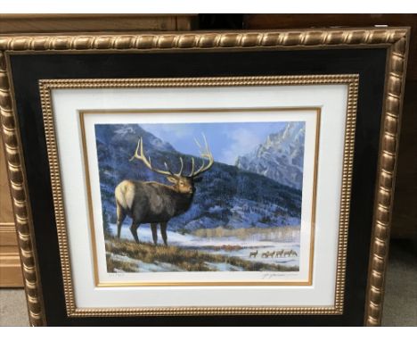 A framed giclee print in colour on paper of a Stag with a herd of deer in the background of a snowy scene titled 'Return to t