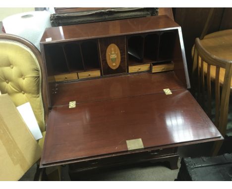 A Mahogany bureau with a cross banded edge well fitted interior above four graduating drawers on swept bracket feet.