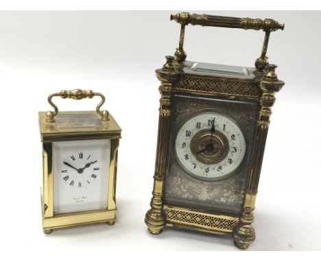 Two clocks. One is an ornate antique french carriage clock and the other A Lionel Peck of London brass carriage timepiece.