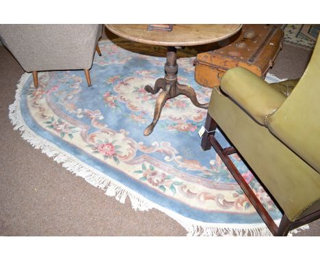 A modern Chinese oval rug with floral decoration on light blue ground.