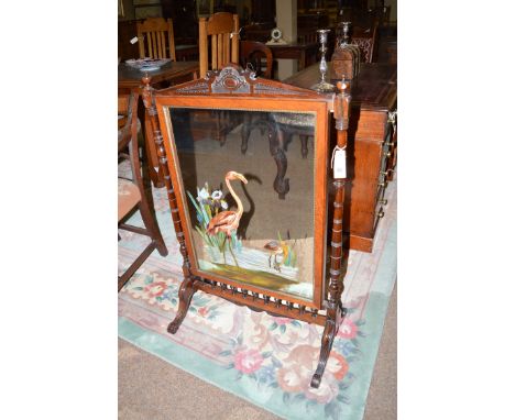 An early 20th Century Victorian rosewood firescreen, the shaped cornice carved with leaf design above a centre mirror panel p