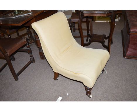 A Victorian nursing chair, with gold upholstery raised on turned legs terminating in ceramic castors.