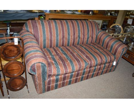 A sofa bed, upholstered in striped floral pattern material.