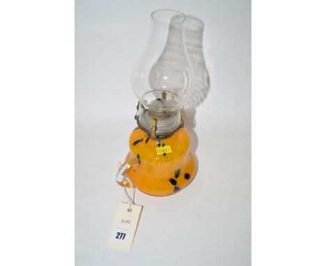 A 19th Century coloured glass hand-held oil lamp with mottled glass reservoir and glass chimney.
