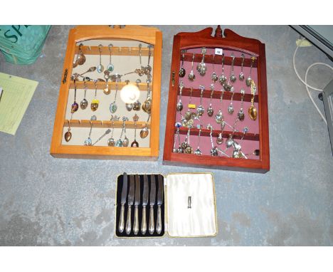 A large and varied collection of silver and plated souvenir teaspoons, in two small wall mounted display cabinets; and a set 