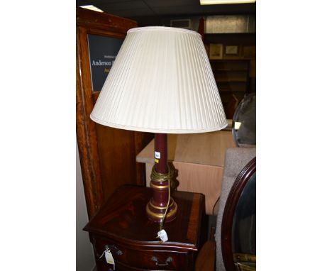 A modern maroon and gold coloured table lamp with tapering pleated cream coloured shade.